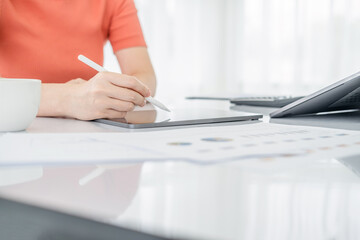 Business woman busy working with documents and tablet  in workstation.