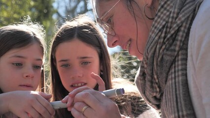 Close-up woman with girls at the park holding an insulin pen