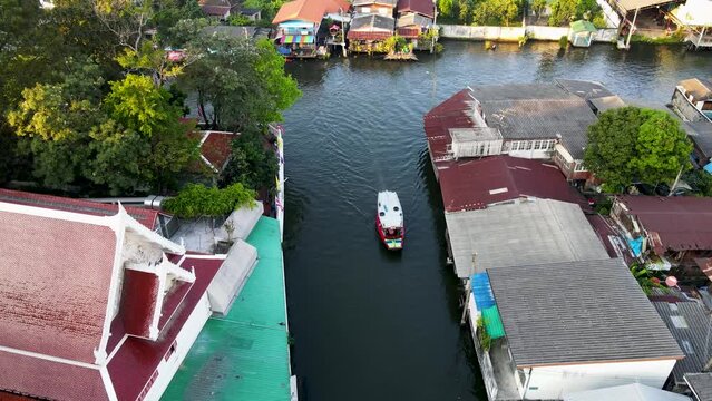 Aerial View Over Khlong Bangkok Yai Canel Waterways With Small Boat Passing By. Dolly Forward