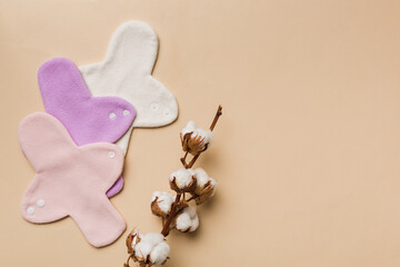 set of colorful bright reusable menstrual pads with cotton flower. zero waste woman periods concept top view with copy space © sosiukin