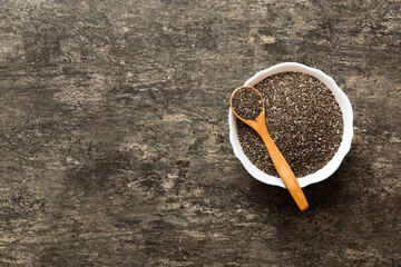 Chia seeds in bowl and spoon on colored background. Healthy Salvia hispanica in small bowl. Healthy superfood