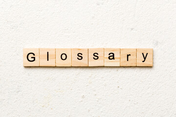 glossary word written on wood block. glossary text on table, concept
