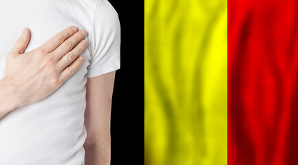 Belgium person with hand on heart on the background of Belgium flag. Patriotism, country, national,...