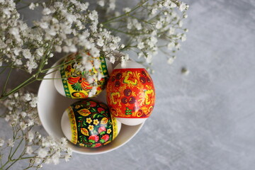 Easter eggs on a table. Still life with eggs and white flowers. Easter celebration concept. 