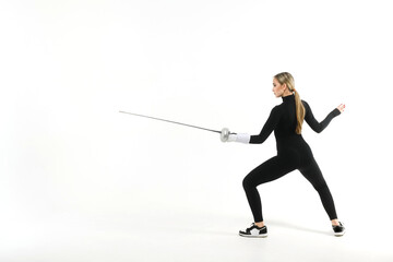 Girl in a black tight-fitting jumpsuit practicing with a sword on a white background