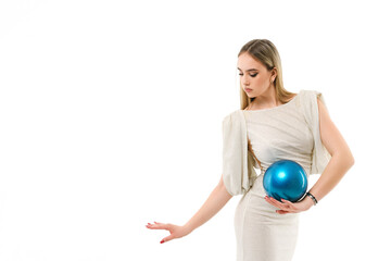 Gymnast dressed in evening dress with ball on white background