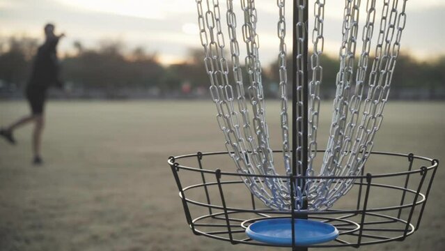 Disc Golfer Makes Second Putt in Disc Golf Basket during Putting Practice for a Disc Golf Tournament