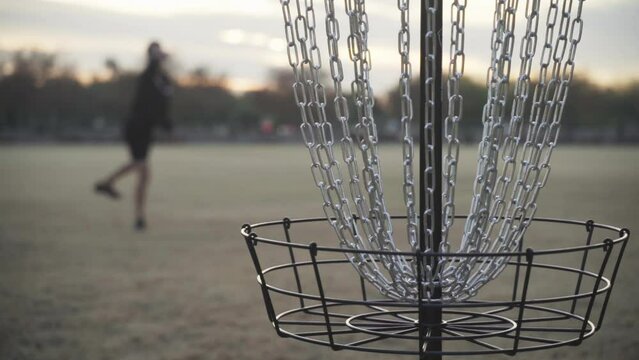 Shallow Depth of Focus Slow Motion Missed Disc Golf Shot that Hits the Chains but doesn't Go in the Disc Golf Basket