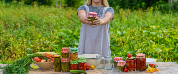 A woman preserves vegetables in jars. Selective focus.