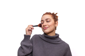 mujer joven utilizando brocha de maquillaje. Fondo Blanco.