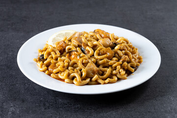 Traditional Spanish fideua. Noodle paella on black background