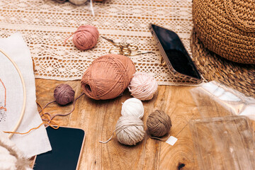 Punch Needle Workshop. Needlework. Materials for knitting at home on the table with phones.