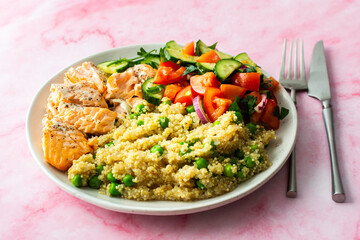 Healthy lunches, quinoa with green peas, with baked red fish salmon and fresh salad of tomato, cucumber and greens