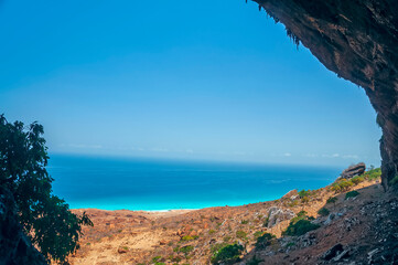 Fototapeta na wymiar View from the top of the cave on the wild coast of the Indian Ocean. Socotra island.