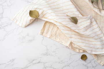 Beige cloth napkins with leaves on marble background