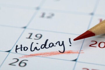 Word holiday written on calendar