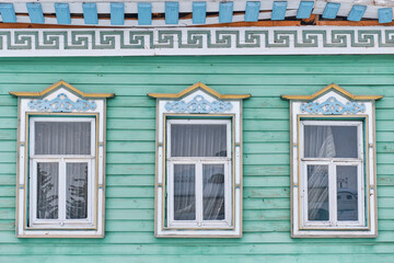 Windows with carved wooden architraves. Facade of typical tatar house.