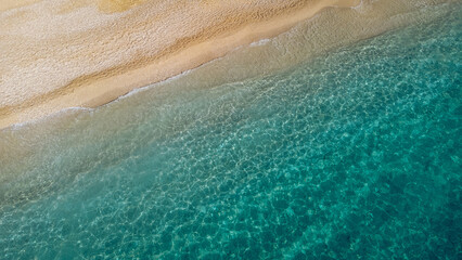 Aerial view of beautiful sandy beach and soft turquoise ocean wave. Tropical sea in summer season on Egremni beach on Lefkada island.