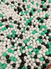 Many multicolored balls white green black as background