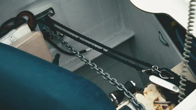 Close-up of anchor lowering on a metal chain through the fairlead. Ropes with metal carabiners. Mooring. Ride on a catamaran.