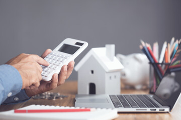 House purchase and cost idea, Home interest calculate concept. Man using calculator on office desk...