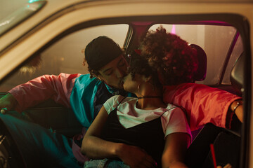 Stylish couple kissing in car.