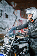 Fototapeta na wymiar Man in a leather outfit riding a motorcycle.