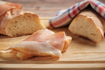 a thin slice of appetizing bacon lies on freshly baked rustic wheat bread