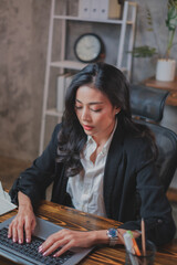 Asian  business woman is focusing while working with laptop. Concept of concentration, serious, professional, planning, work hard and intend work. stressful female lawyer or secretary.