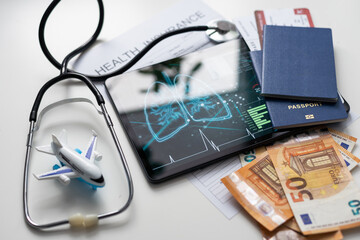 Modern social health insurance program. Tablet computer with healthcare application interface on screen. Stethoscope, x-ray image and cardiogram on wooden desk. Digital healthcare technologies.