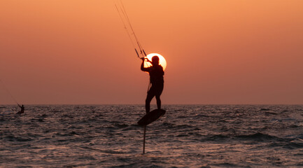 People ride a Kiteboarding during the sunset. Mediterranean sea, Israel