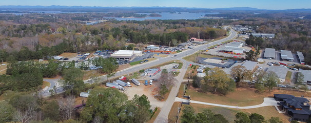 Panorama aerial view Lanier Island Parkway with farm ranch style residential houses, commercial buildings and Lake Lanier in background in Buford, America