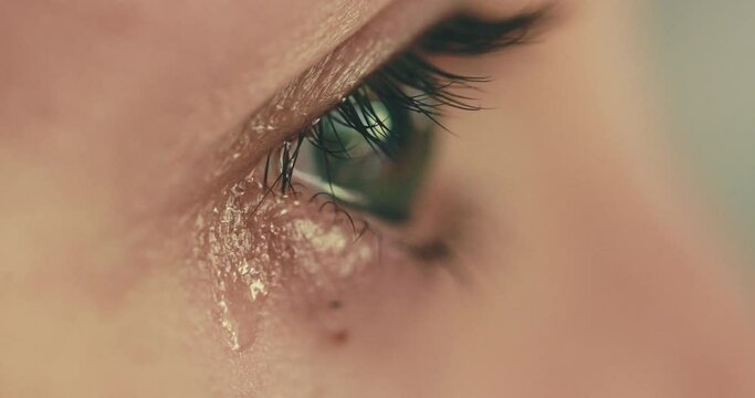 Eye with tears. Close up of crying persons' eye. Sad Woman with anxiety in stress, desperation, burnout, grief or depression experiencing severe mental breakdown. Mental emotional health.