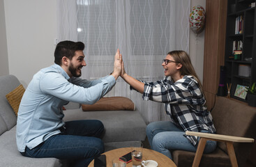 Couple having fun at home playing pantomime game, explaining, acting and guessing. Friends...