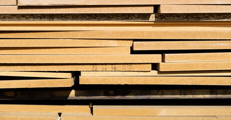 Plywood stacked in layers outdoors. warm sunshine