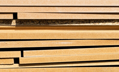 Plywood stacked in layers outdoors. warm sunshine