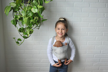 criança carinhosa brincando com boneca bebe 