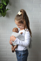 criança carinhosa brincando com boneca bebe 