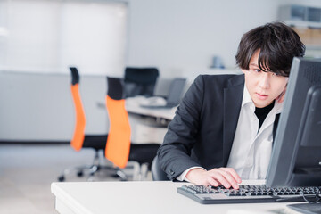 遅い時間まで一人で残業をするビジネスパーソン