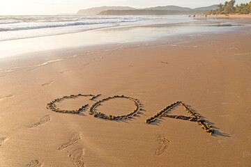 GOA word on sandy surface, summer beach with ocean shore