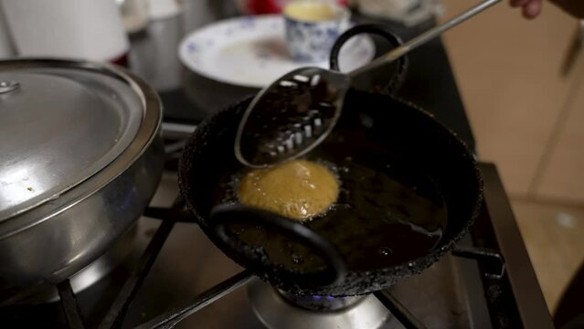 Metal Slotted Spoon Gently Moving Floating Fresh Guror Handesh In Pan Filled With Hot Oil. Locked Off
