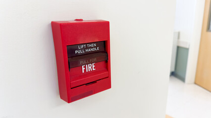 red fire alarm switch in the industry to prevent and protect by warning for fire in an emergency symbolizing rescue security and safety during and urgency in building or nearby school and office