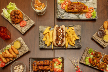 Set of recipes for Cuban food, fast food and Venezuelan food, a hot dog with sauces, some teques, a tamale, battered chicken and sauces