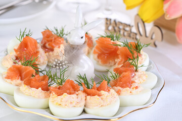 Appetizer of eggs stuffed salmon pate and yolks with salmon slices. Idea Easter table 