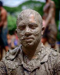 South asian hindu religious young aged handsome man playing with mud in bijoya dashami of Durga puja