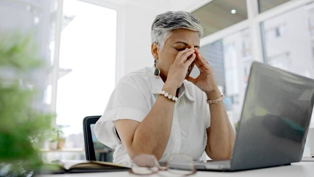 Tired, headache and business woman at laptop with anxiety, mental health and problem. Frustrated, burnout and stressed female working online at desk with fatigue, debt risk and depression of failure