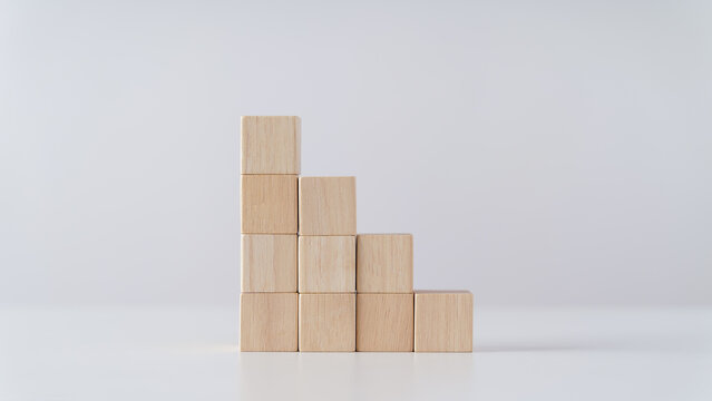 Pile of wooden cube block stack as stair step on the table. Success, climbing to the top, Progression, business growth concept.