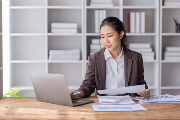 Fototapeta premium Business Asian woman working at office with documents on her desk, calculator to calculate planning analyzing the financial report, business plan investment, finance analysis concept