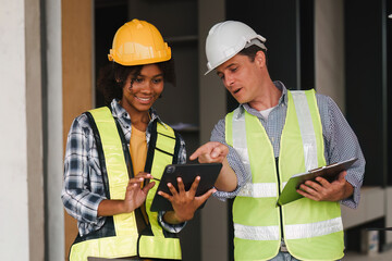 Engineer and Foreman builder team at construction site. American African foreman construction standing at construction site