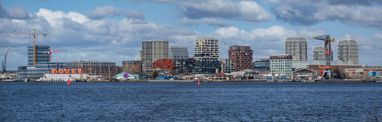 Panoramic view from the IJ river to NDSM neighborhood (Amsterdam-Noord borough), located on the former terrain NDSM-wharf, along the IJ river. AMSTERDAM, The NETHERLANDS.